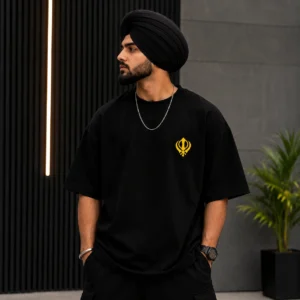 Model wearing black oversized t shirt with yellow Khanda left chest logo streetwear style