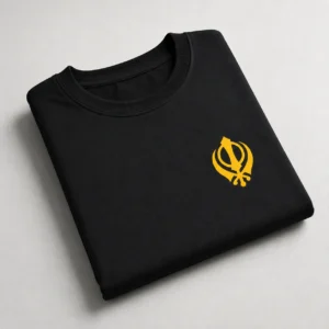 Folded black oversized t shirt with yellow Khanda chest logo on light background